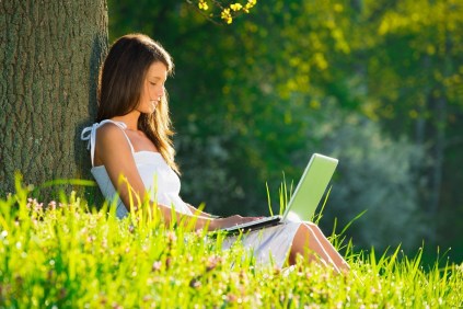 19428711 - beautiful young woman relaxing on grass with laptop